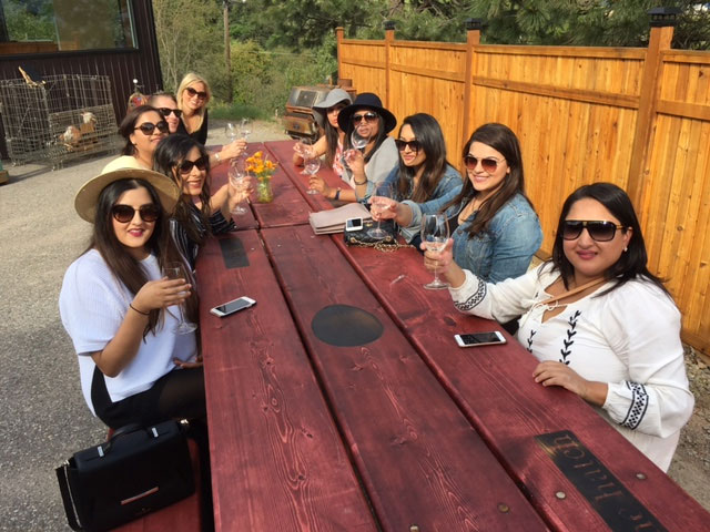 Several women tasting wine at large table on wine tour